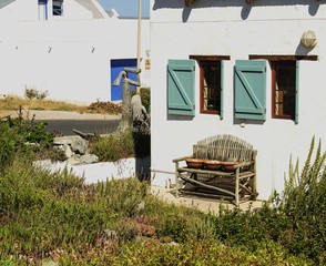 old wooden bench standing next to fishermen's white houses