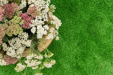 Autumn composition of wild and ornamental flowers . Bouquet on green background of artificial grass.