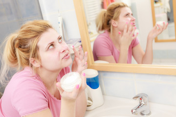 Obraz na płótnie Canvas Woman applying face cream with her finger