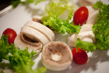 preparation of champignones mushrooms and tomato salad