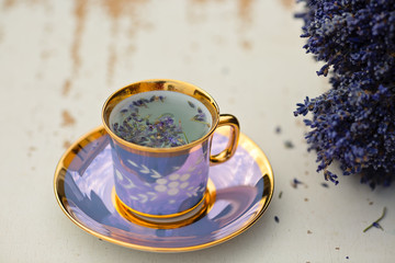 Obraz na płótnie Canvas Close-up photo of freshly prepared hot cup of lavender loose tea placed on a wooden table