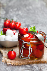 Marinated  cherry tomatoes stuffed with mozzarella and spices on wooden table