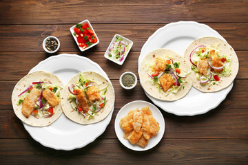 Plates with fish tacos on wooden table