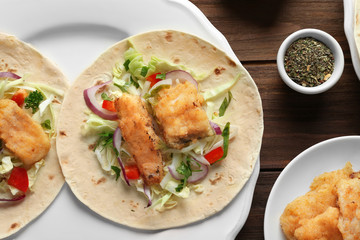 Plate with fish tacos on wooden table