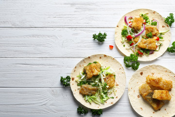 Tasty fish tacos on wooden table
