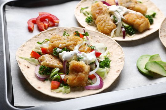 Tasty fish tacos on baking tray