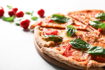 Delicious pizza, cherry tomatoes and fresh basil on light background