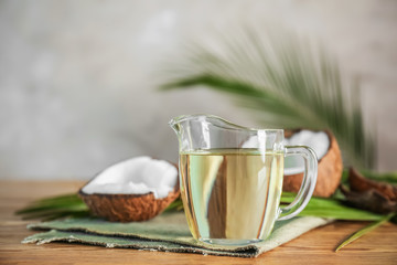 Pitcher with coconut oil on wooden table