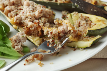Quinoa stuffed zucchini served with arugula, closeup