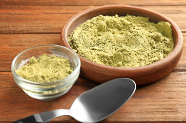 Composition with hemp protein powder in bowls on wooden table