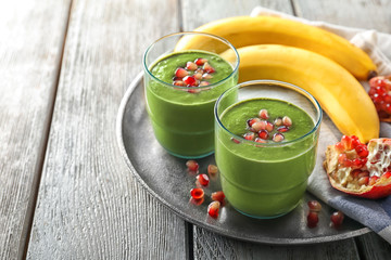 Glasses of fresh green smoothie on metal tray