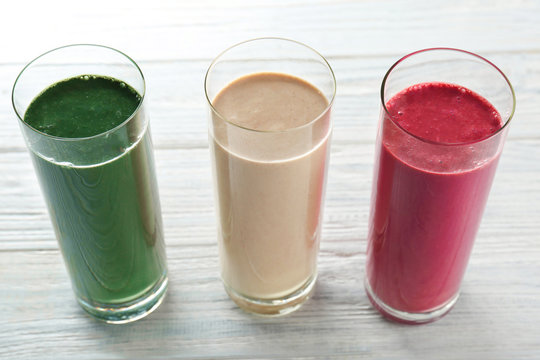 Glasses with different smoothies on table