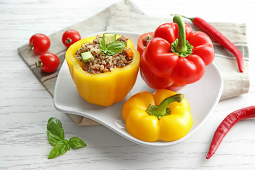 Quinoa stuffed peppers on white plate in kitchen