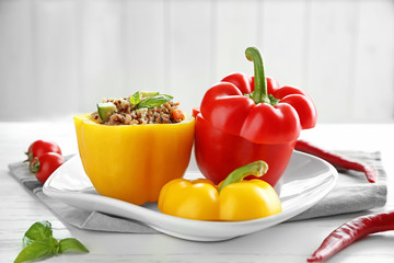 Quinoa stuffed peppers on white plate in kitchen