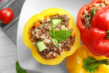 Quinoa stuffed peppers on white plate in kitchen