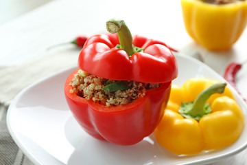 Quinoa stuffed peppers on white plate in kitchen