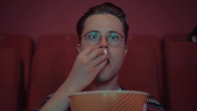 A Young Hipster Eating Popcorn While Watching The Premiere Of A Motion Picture And A Television Series Of A Soap Opera