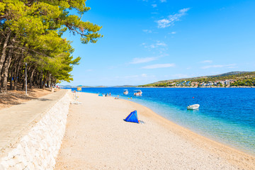 Coastal walkway and blue tent on idyllic beach in Primosten town, Dalmatia, Croatia