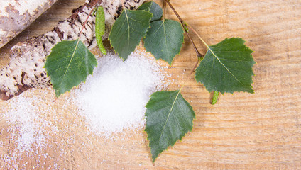 Xylitol - sugar substitute. Birch sugar on wooden background.