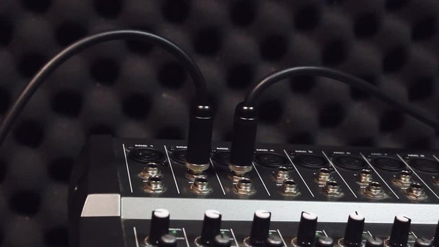 selective focus hand someone connect USB connectors of microphone on the sound music mixer.Mix variety object in the home studio recording.
