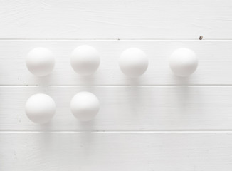 White eggs on a white wooden table