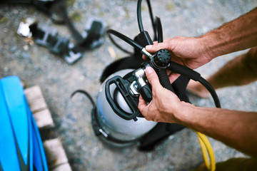 Male hands checking diving equipment before immerse