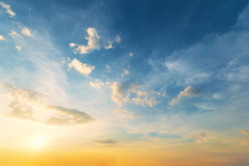 Fototapeta premium Niebo w tle o zachodzie słońca, błękitne niebo i pomarańczowe światło słońca przez chmury na niebie