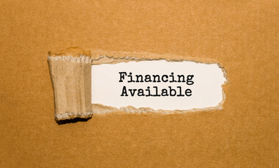 The text Financing Available appearing behind torn brown paper