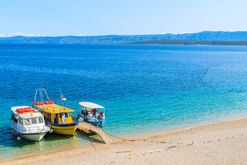 Tourist boats on beautiful Zlatni Rat beach in Bol town, Brac island, Croatia