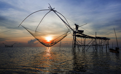 fishermen catching prawns early morning unique dip fishing net used by fishermen and women for catching prawns from the freshwater lake located in Phatthalung province, Thailand