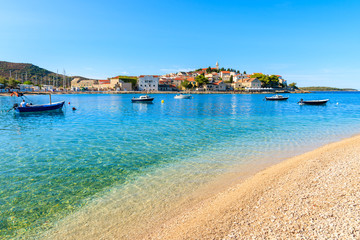 Pebble stone beach with crystal clear turquoise sea water in Primosten town, Dalmatia, Croatia