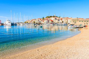 Pebble stone beach with crystal clear azure sea water in Primosten town, Dalmatia, Croatia
