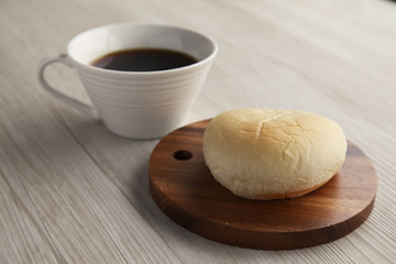 木のまな板にのせた 白パンとコーヒー