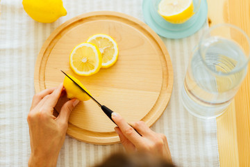 Young woman preparing lemonade in kitchen, closeup, top view