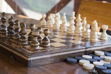 Chess on the game board. Checkers on the table near the game board outdoor. concept of  intellection. wooden table and bench with chess on the summer house.