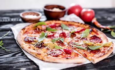 Delicious spicy pizza on wooden background