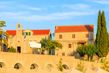 View of typical old houses and church in Bol port at sunset time, Brac island, Croatia