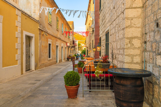 Fototapeta Restaurant tables on street of Bol port old town, Brac island, Croatia