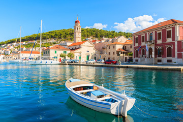 Fishing boat in Pucisca port with beautiful church in background, Brac island, Croatia - obrazy, fototapety, plakaty