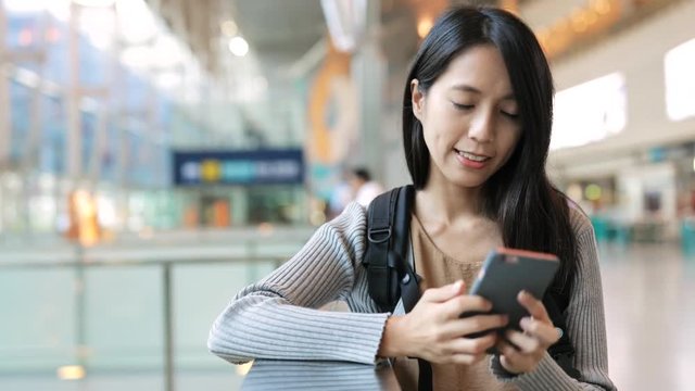 Woman working on mobile phone in the station