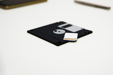 Memory card and old floppy disk. Memory card stand near floppy disks as background. Old and new technology concept.