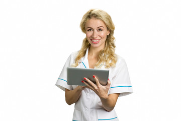 Happy young nurse with computer tablet. Smiling young girl in white uniform holding digital tablet and looking at camera on white background.