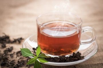 Hot cup of tea for break time on hemp sack background in vintage style in morning