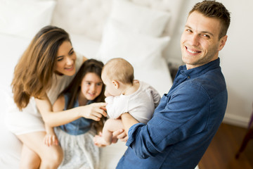 Obraz premium Young parents with daughters in the room