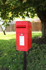 Small oblong red postbox in UK