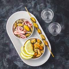 Seafood mix - mussels, calamari, octopus and alcohol drinks on dark stone background. Top view,copy space.