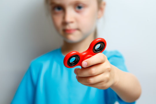 kid hand holding popular fidget spinner toy