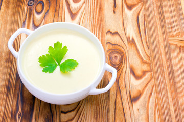 Potato and onion vegan, vegetarian healthy cream soup in white bowl. Tasty potato soup with a leaf...