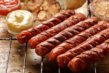 Grilled sausages with sauce ketchup and mustard on metal grate