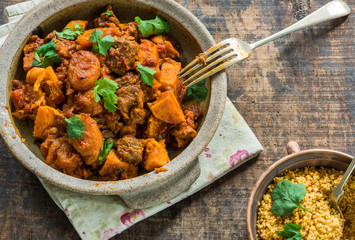 Maroccan lamb tajine with couscous garnished with fresh coriander leaves